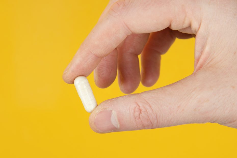 Tablettenkapsel zwischen Daumen und Zeigefinger