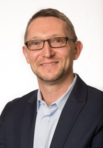 Portraitfoto von Dr. Thomas Vorwerk, Chefapotheker des KRH Klinikums Region Hannover  und Präsident des Bundesverband deutscher Krankenhausapotheker. Ein Mann mit Brille und dunkelblauem Anzug lächelt in die Kamera.